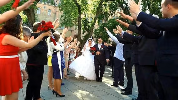 esküvő videóból vágott kép, a pár és a násznép a szertartás után